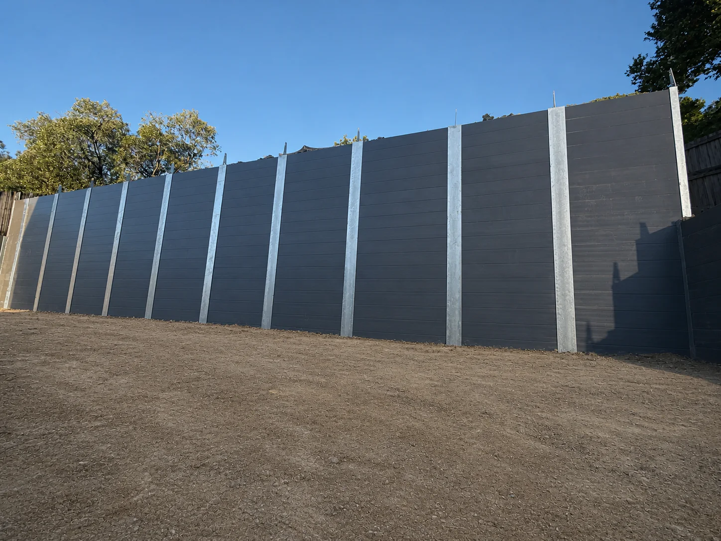 Engineered charcoal concrete sleeper retaining wall on a civil construction site