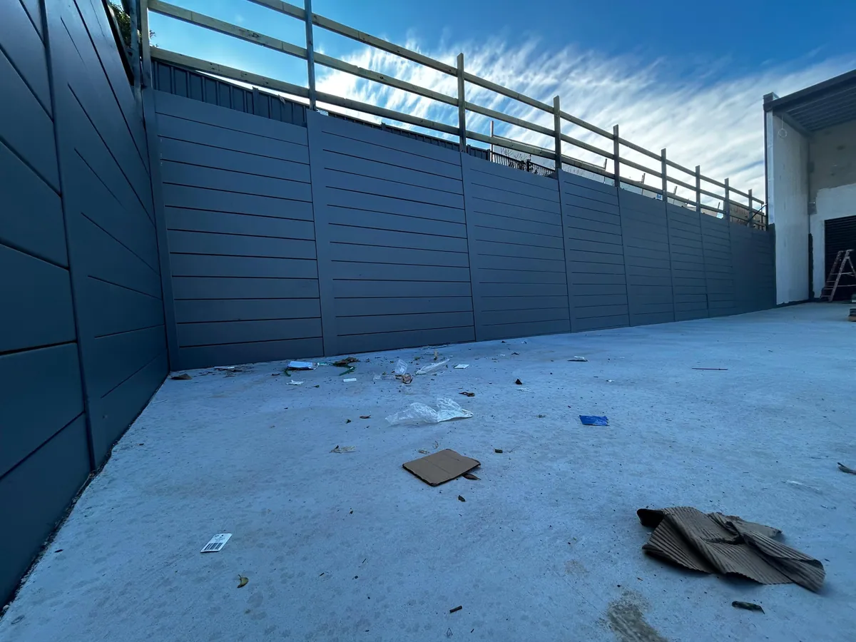 Commercial retaining wall with safety railing beside a service yard
