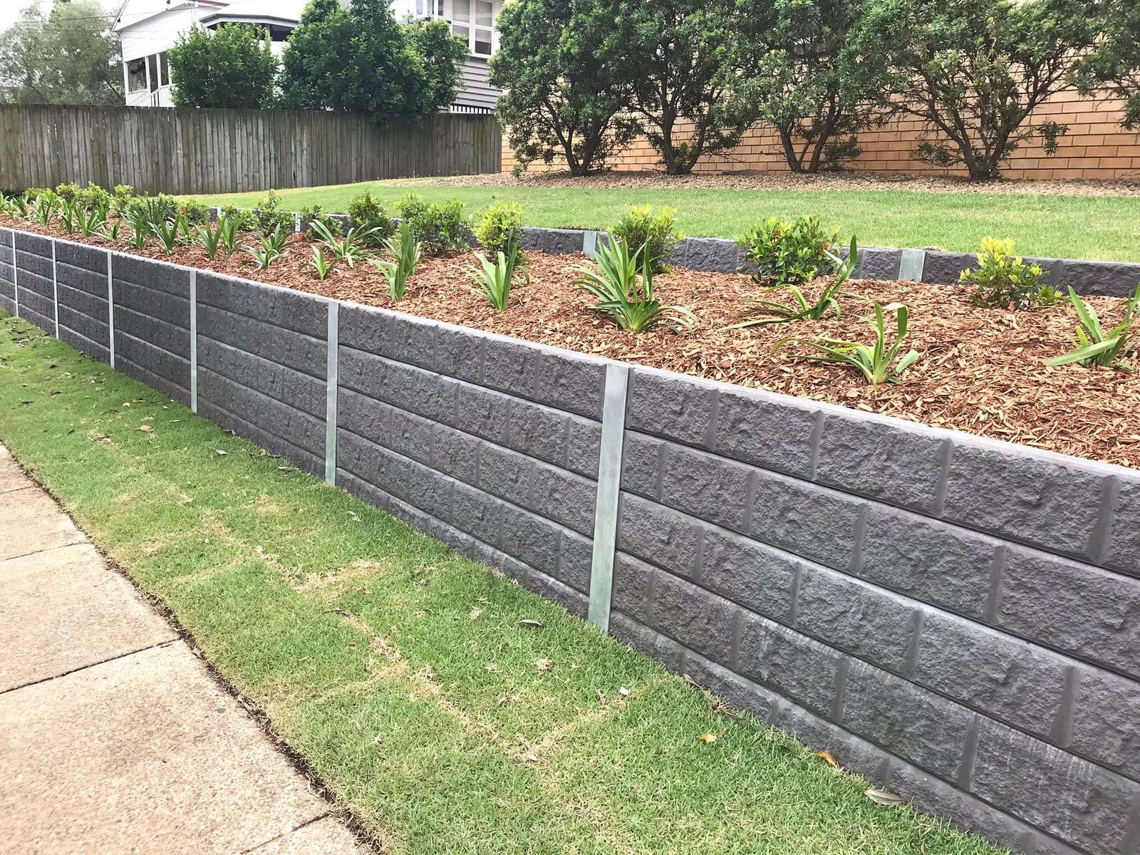 Decorative concrete sleeper retaining wall with landscaping