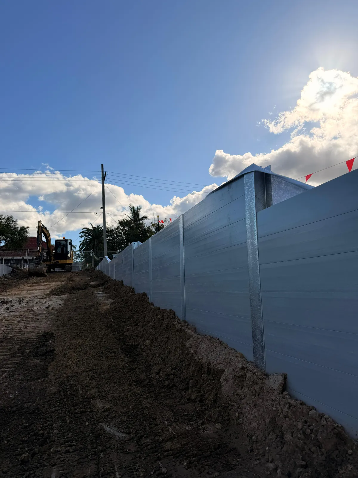 Tall SuperSleeper wall with excavator on site