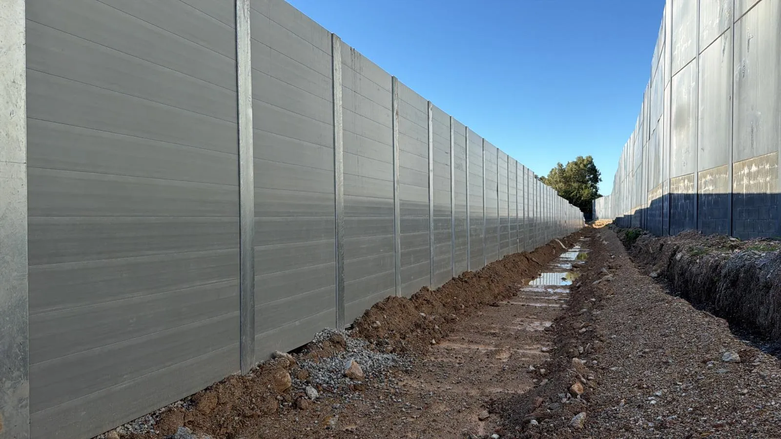 Long SuperSleeper retaining wall installation, blue sky